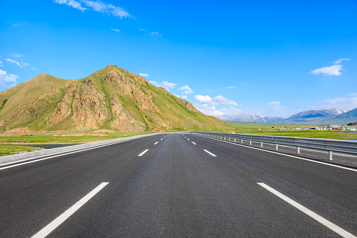 Asphalt highway and mountain with sky clouds background