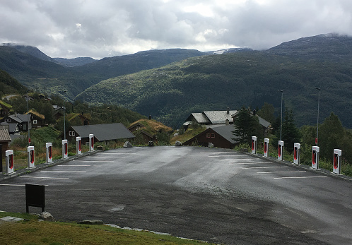 Roldal, Norway - August 27 2019: View over a parking lot in the mountains with Tesla charging stations for electric cars with a view of mountains in the background