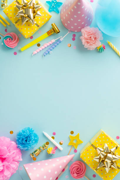 istock Festal birthday bash inspiration. Vertical top view capturing the festive ambiance with presents, hats, lollipops, balloons, and confetti on pastel blue background. Suitable for text or promo content 1937428196