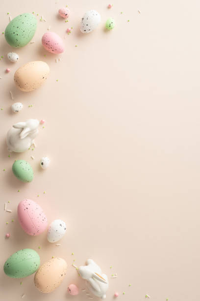 istock Bunny Bliss Arrangement: Vertical top view of vibrant Easter eggs, charming ceramic bunnies, and sugar sprinkles on a soft pastel surfaceâideal for adding your text or promotional content 1937429231