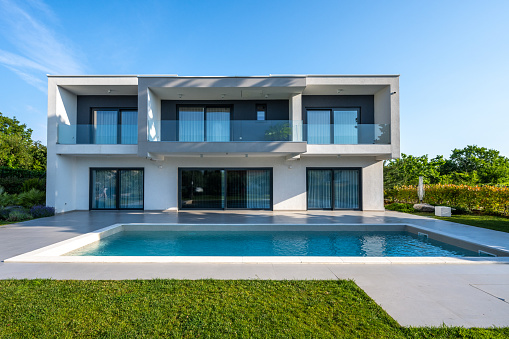 Luxury modern house exterior with swimming pool at sunny day wide shot