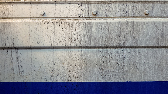 white and blue metal wall with rivets, background or texture.