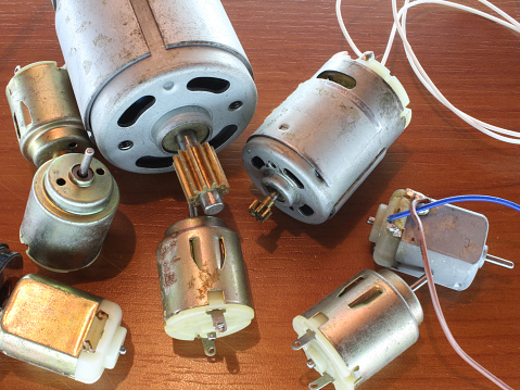 electrical toy motors on a wooden table, close-up of electronic parts