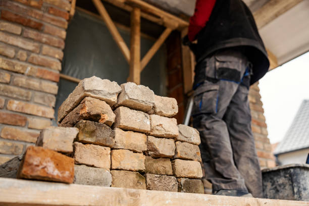 istock Low angle view of builder building a house. Selective focus on pile of bricks. 1937458294