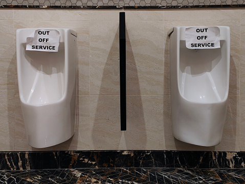 Wall mounted men's urinal in toilet - Typo error on Out of Service notice