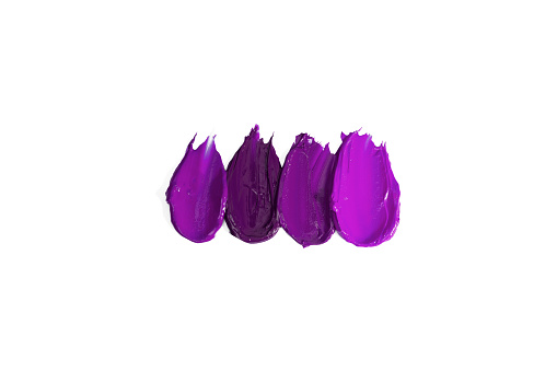 Pattern smears and textures of lipsticks or acrylic paints isolated on white background. Cream makeup texture. Bright purple color cosmetic product brush stroke swipe sample. Top view