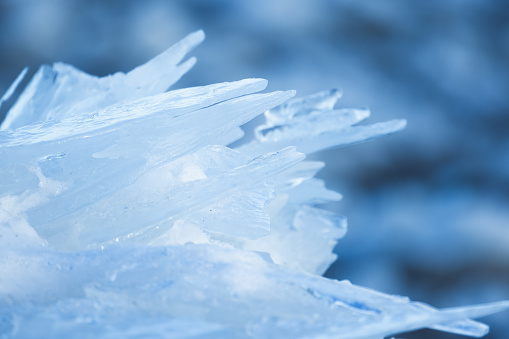 Ice shards close up photo with selective soft focus and blurred blue background