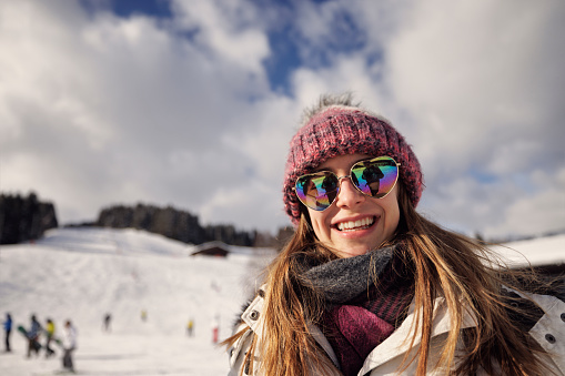 Portrait of beautiful, generation z teenage girl on ski slope in Alps.\nCanon R5