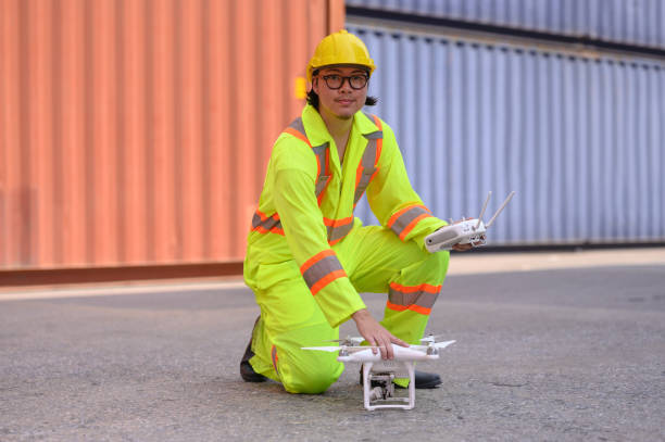 istock An engineer or worker uses a remote control to control a drone at a container port to inspect containers. Foreman uses a remote-controlled drone with camera flying on a container ship at a shipping po 1937525194