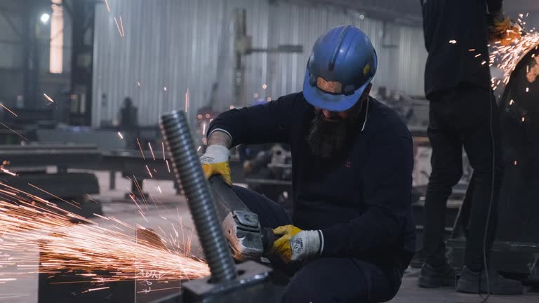 Metal workers using a grinder