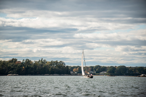 A small sailboat on the open water in Casco Bay in Maine in the fall