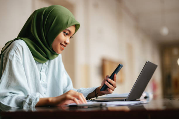 istock Portrait of a Beautiful Indonesian Female Student Using Mobile Phone While Studying 1937530708