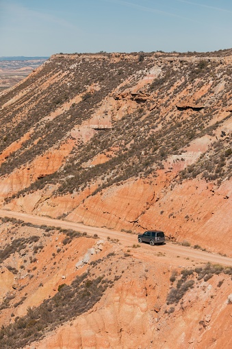 A compact automobile traversing a remote hillside