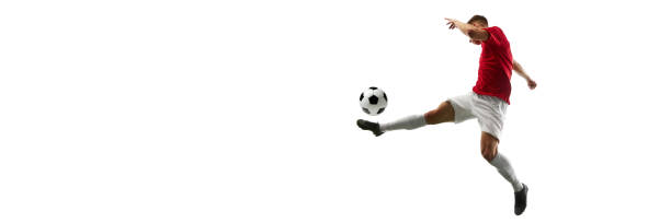 istock Precision in Flight. Football player kicks ball into air, creating visual masterpiece against white background with negative space to insert text. 1937544836