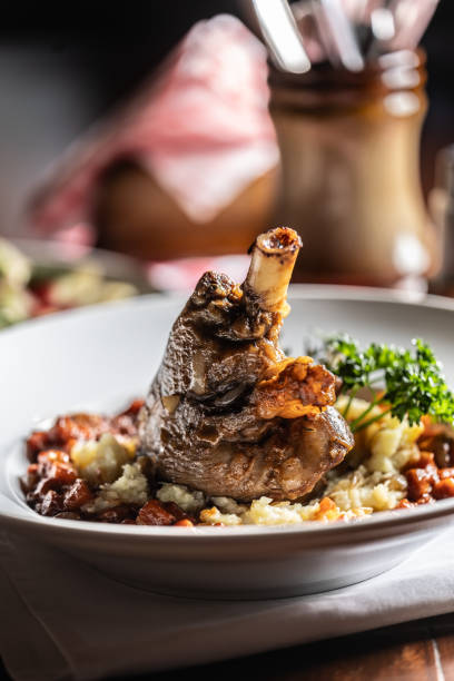 istock Confit lamb calf on mashed potatoes and baking sauce. Roasted leg of mutton with potatoes on a plate in a restaurant. 1937549976