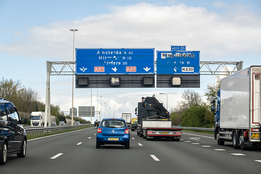 UTRECHT, NETHERLANDS - MAY 25, 2023: Traffic and unreadable direction signs on motorway A27 from Utrecht to Amsterdam
