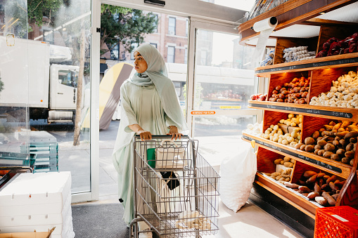 Woman in Abaya entering a grocery store in New York.