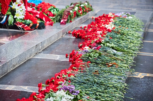 Volgograd, Russia - May 06, 2023.: Eternal flame in the Hall of Military Glory on Mamayev Kurgan. Commemorative carnation flowers for soldiers who died in World War II and the Great Patriotic War.