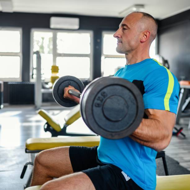 confident man training muscles with barbell - body building determination deltoid wellbeing fotografías e imágenes de stock