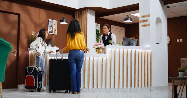 istock Asian tourists entering hotel lobby and using service bell 1937575569