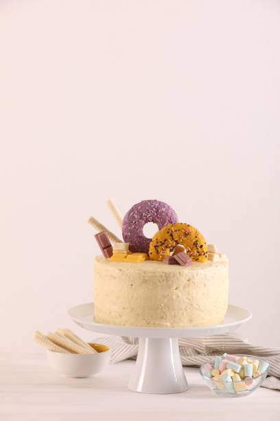 istock Delicious cake decorated with sweets, wafer rolls and marshmallows on white wooden table, space for text 1937582620