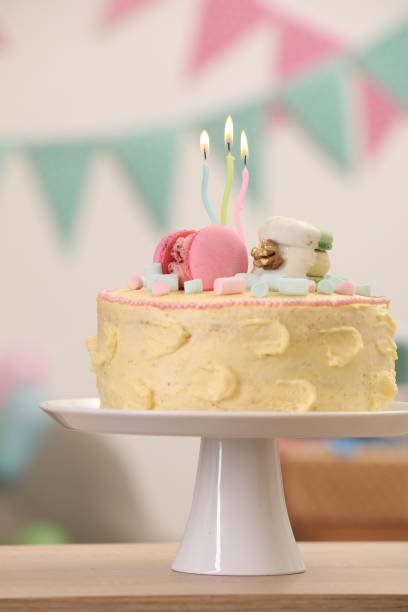 istock Delicious cake decorated with macarons and marshmallows on wooden table against blurred background, closeup 1937582630