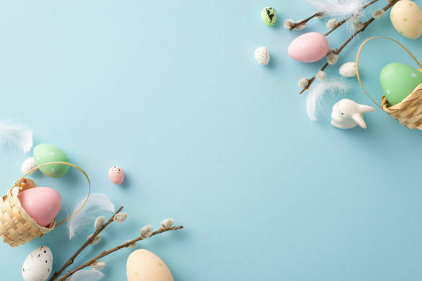 istock Explore essence of Easter spring with delightful top-view shot featuring colorful eggs in tiny baskets, charming bunny, pussy willow, all set against soft blue background. Perfect for text or advert 1937583144