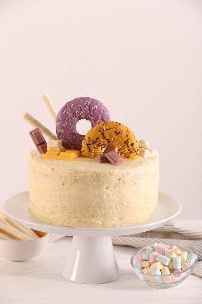 istock Delicious cake decorated with sweets and marshmallows on white wooden table 1937583706