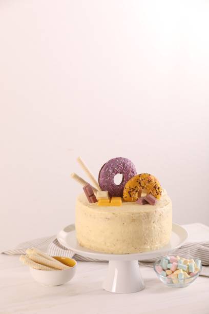 istock Delicious cake decorated with sweets, wafer rolls and marshmallows on white wooden table, space for text 1937584807