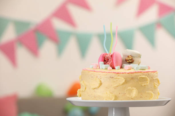 istock Delicious cake decorated with macarons and marshmallows against blurred background, space for text 1937585876