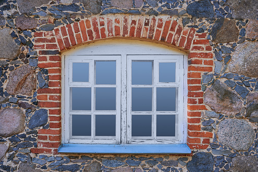 Horizontal shot of close up window. The wall of a stone old house.