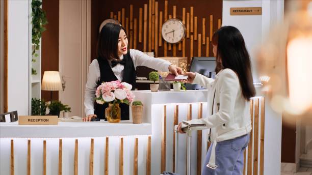 istock Front desk staff giving passport and access room card to client 1937595921