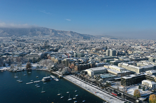 Zurich city snowcovered. The panoramic high angle image shows the city during winter season on a sunny day.