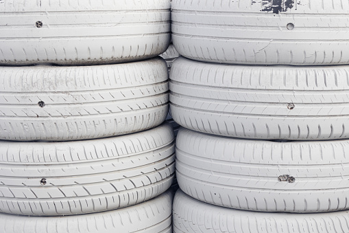 Two colums of stacked white painted wheels with details at Montmeló circuit in Barcelona.