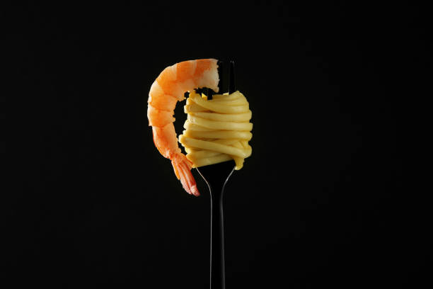 istock Fork with tasty pasta and shrimp on black background 1937614633