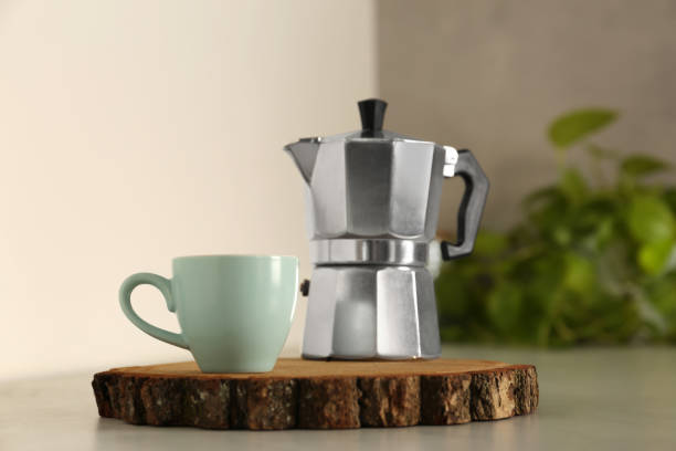 istock Ceramic cup and moka pot on light countertop in kitchen 1937625945