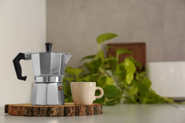 istock Ceramic cup and moka pot on light countertop in kitchen, space for text 1937626485
