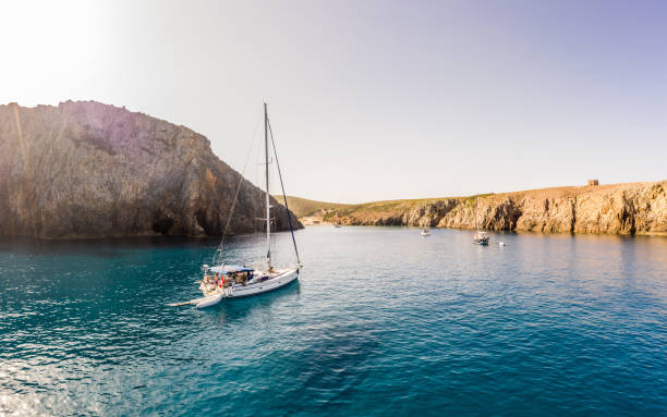 istock High cliffs frame the Cala Domestica Bay, western Sardinia, Italy. Sardinia is the second largest island in the Mediterranean Sea. Sailing boats anchored in Paradies 1937631956