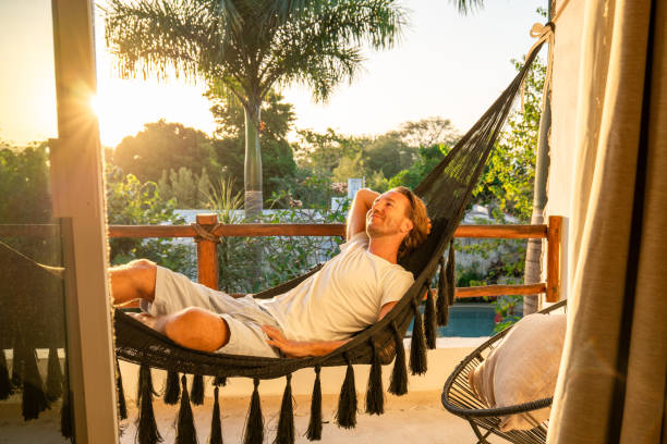 istock Man relaxing in an hammock on her balcony at sunrise 1937633015