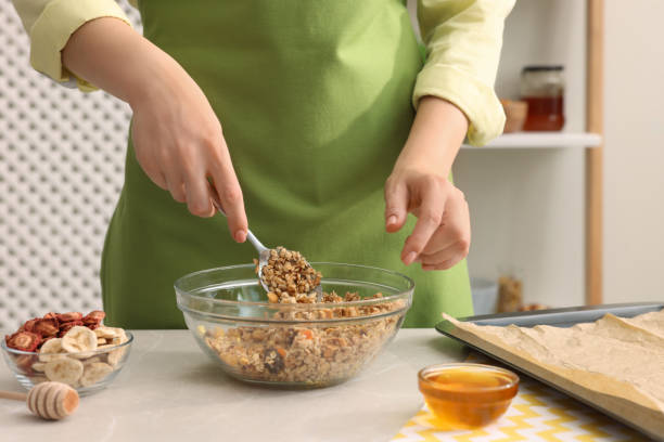 istock Woman making granola at light marble table in kitchen, closeup 1937650529