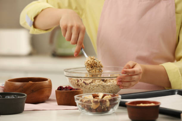 istock Woman making granola at table in kitchen, closeup 1937657896