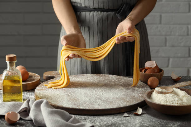 istock Woman making homemade pasta at table, closeup 1937666851