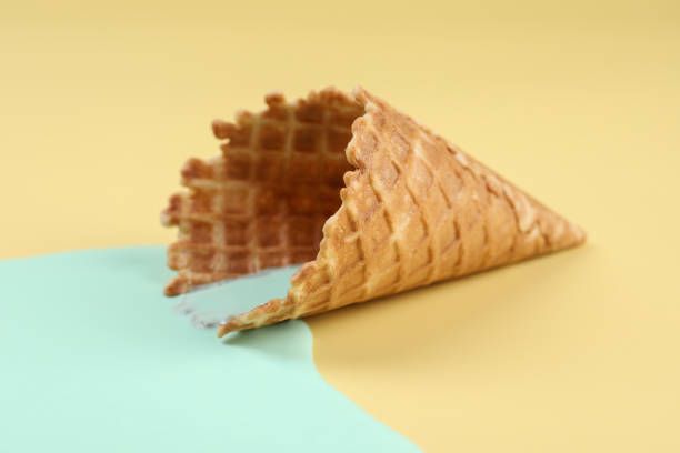 istock Melted ice cream and wafer cone on beige background, closeup 1937667930