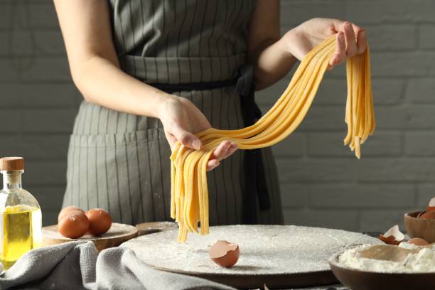 istock Woman making homemade pasta at table, closeup 1937669524
