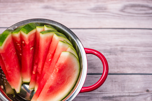 slices of juicy watermelon in a metal strainer