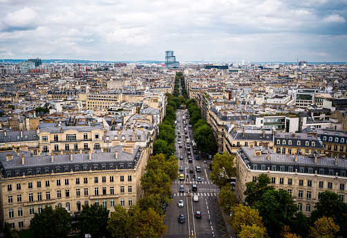 Paris, beautiful Haussmann facades in a luxury area of the capital, with the Eiffel Tower and Montmartre hill in background