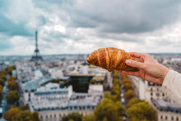 istock Woman holding a croissant on the Arc de Triomphe 1937689038