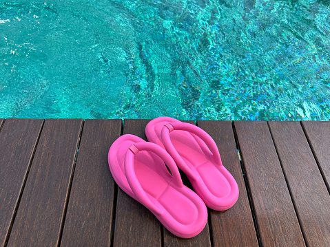 Bright pink sandals, sarong and striped raffia beach bag