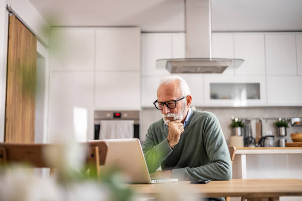 istock A pensioner sits at the dining room table and works on a laptop 1937728393