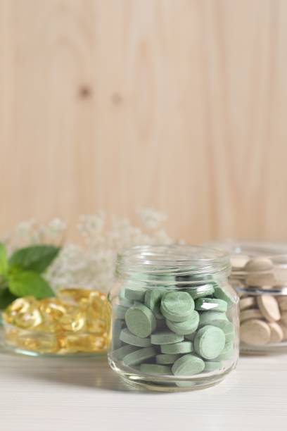 istock Jars with different pills on white wooden table, space for text. Dietary supplements 1937734196